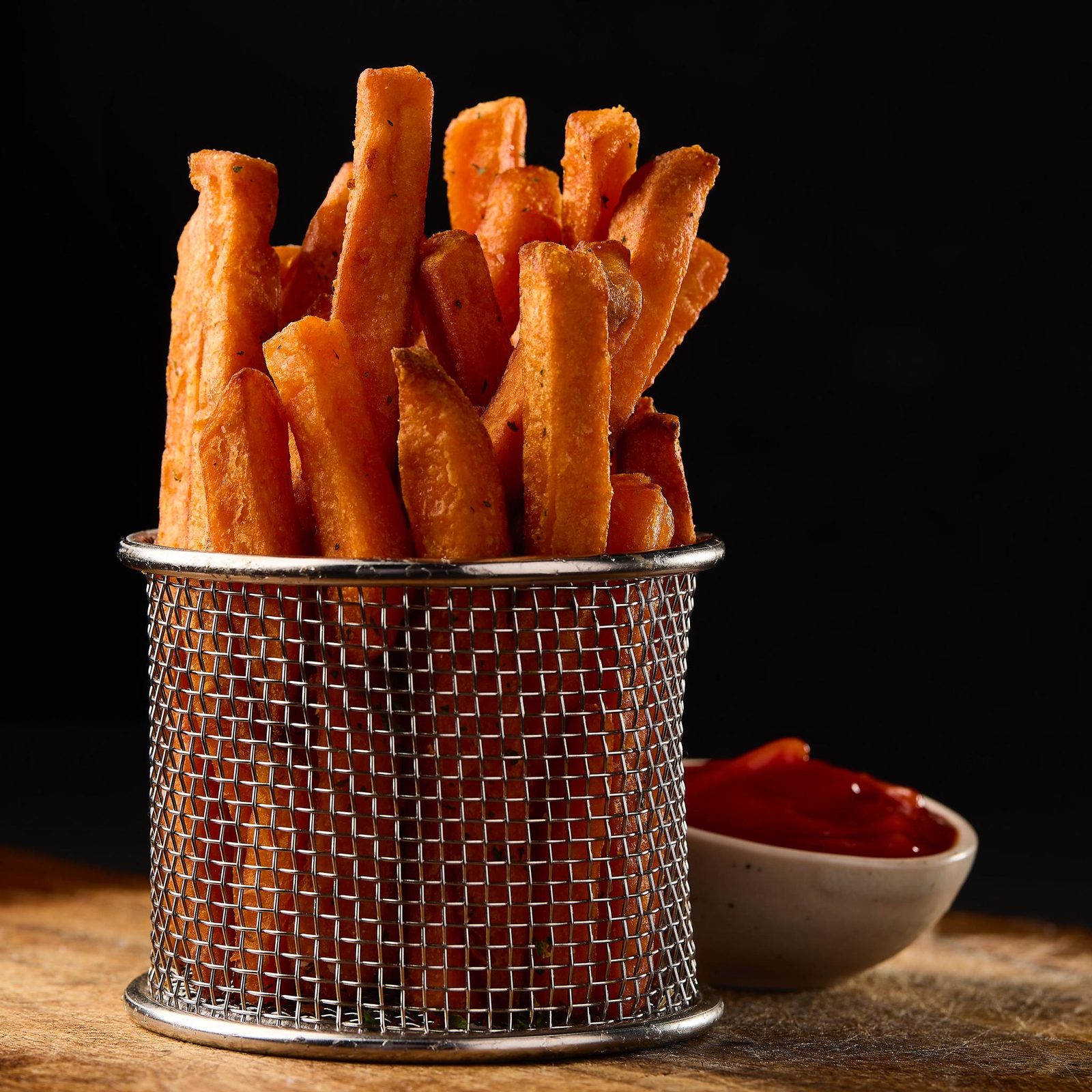 Basket of crispy sweet potato fries with ketchup