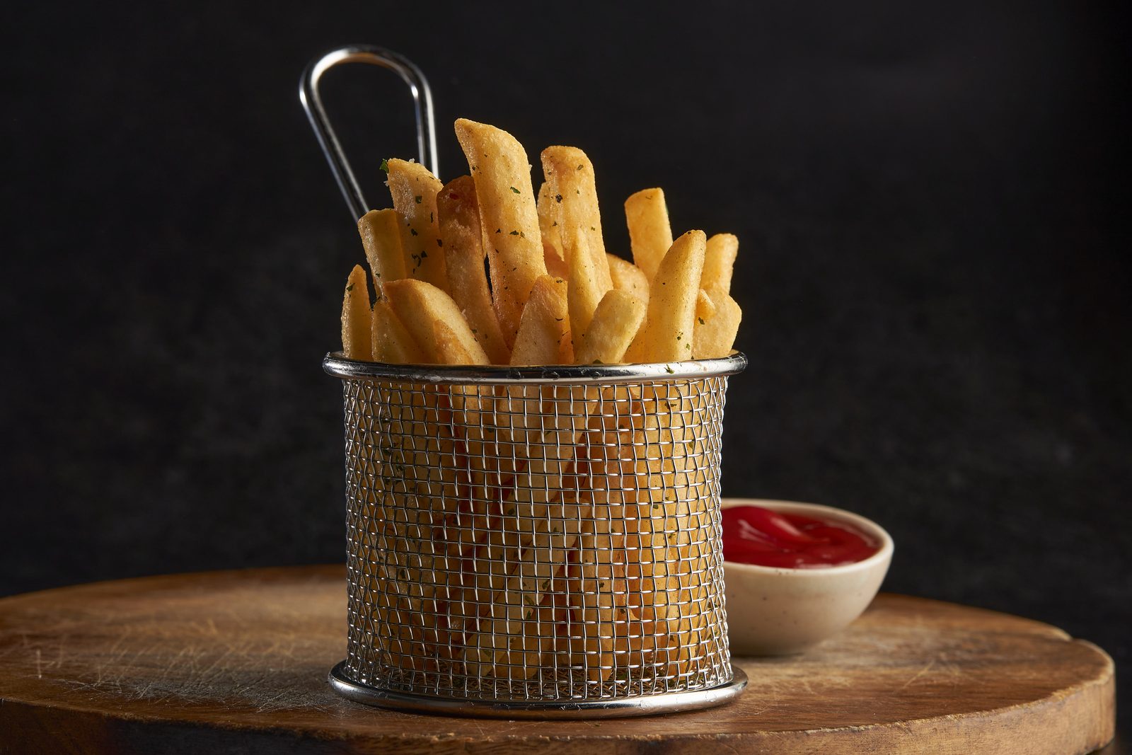 Basket of golden potato fries with ketchup