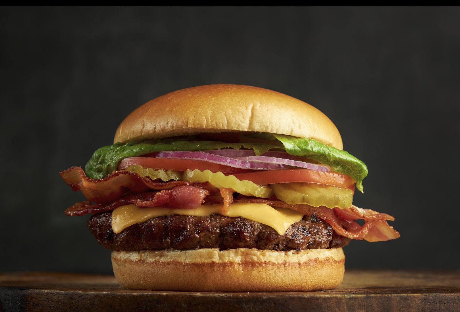 Bacon cheeseburger with lettuce, tomato and red onion