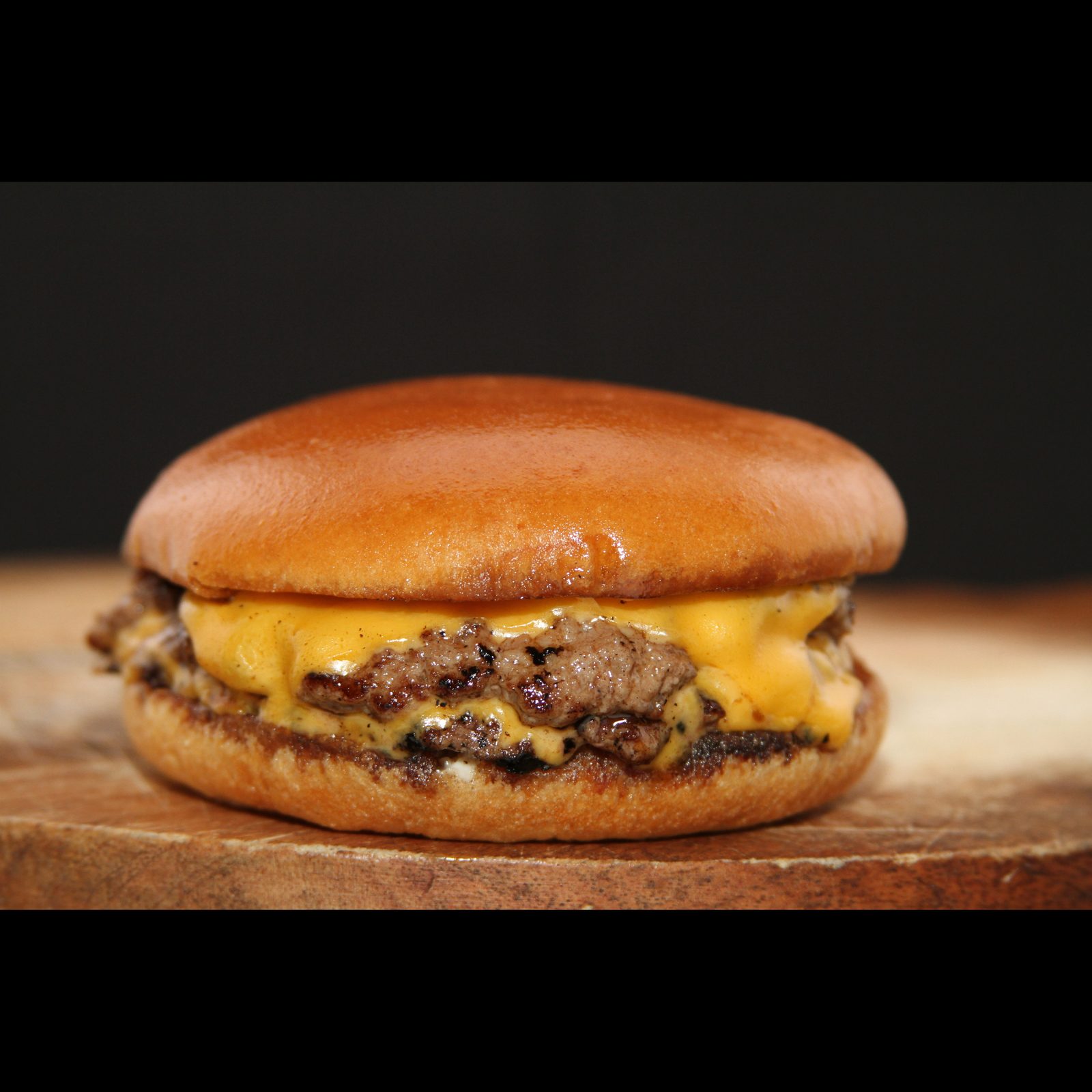 Smashed cheeseburger with melted American cheese on a toasted brioche bun
