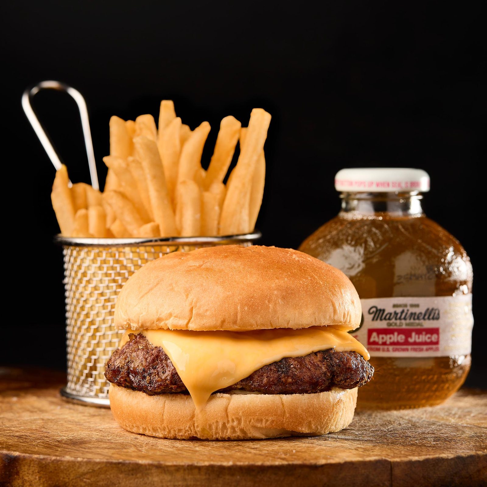 Cheeseburger combo meal with a basket of fries and a bottled apple juice